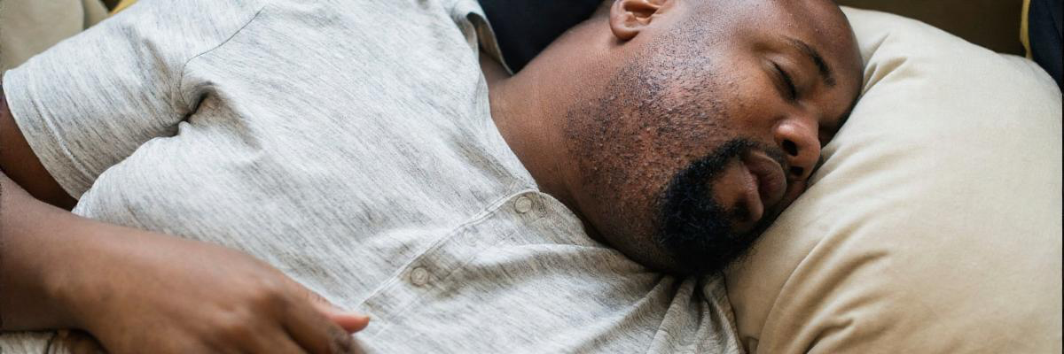 Tired person lying awake in bed with trouble sleeping, representing common sleep problems.